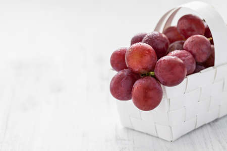 red grapes in a basket with copy spaceの写真素材