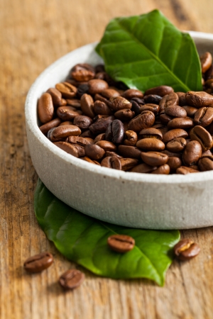 coffee beans and coffee leaves in a bowl の写真素材