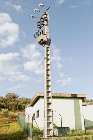 Electric Pylon with transformer and station building against landscapeの写真素材