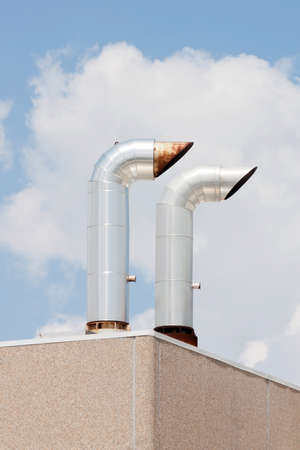 two small industrial chimneys on the top of buiding, without smoke の写真素材
