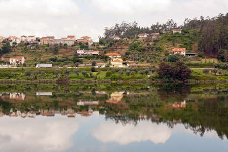 Landscape of a small village with its reflection in the riverの写真素材