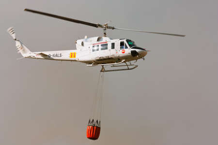 POMBAL, PORTUGAL - OCTOBER 1 : Fire rescue heavy helicopter, with water bucket, going to fire in...