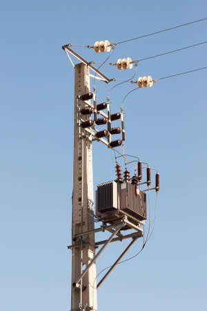 Detail of Electric Pylon with Transformer against blue sky 