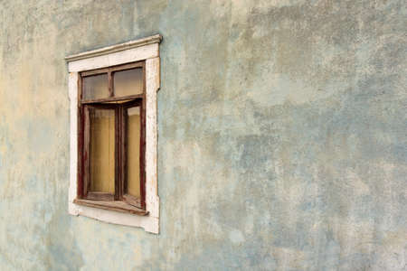 Rusty wood window on aged blue wall