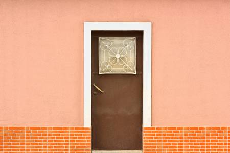Red Metal Door on pink old facade
