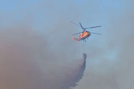 POMBAL, PORTUGAL - JULY 15: Fire rescue heavy helicopter dropping water on a wildfire, in Pombal, Portugal on July 15, 2012 のeditorial素材