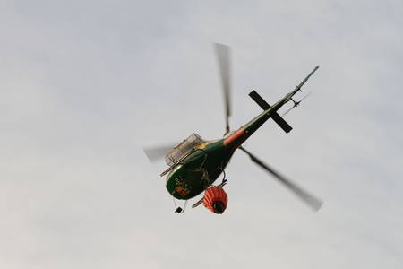 POMBAL, PORTUGAL - SEPTEMBER 22: Fire rescue helicopter, with water bucket, after water drop on Wildfire, in Pombal, Portugal on Setember 22, 2012 のeditorial素材