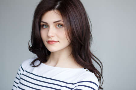 Beauty and sensual face woman with green eyes and long brown hair, posing in studio, natural lights.