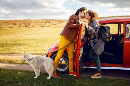 A young couple spend time together outside with their husky dog. Romantic concept lifestyle.の写真素材