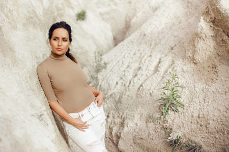 Cool young girl leaning on a rock. Horizontal outdoors shot.の写真素材
