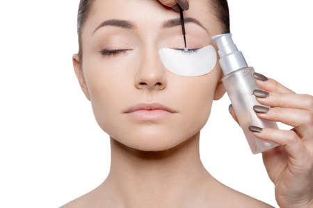 Face of woman with the bottle making cosmetic procedure with eyes closed.の写真素材