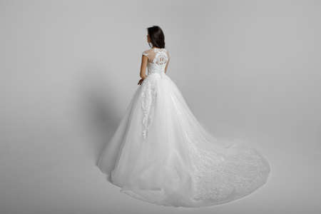 Back view of a elegantly female model in beautiful wendding dress, isolated on a white background.の写真素材