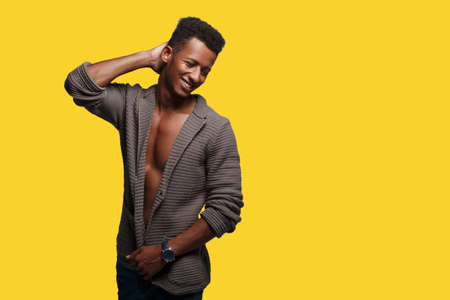 Handsome mixed race man posing amusing in brown cardigan, with naked torso, shot in studio, isolated...