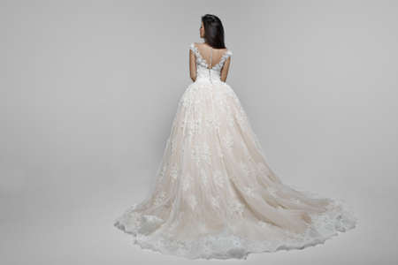 Back view of a beautiful female model in long wendding dress, isolated on a white background.の写真素材