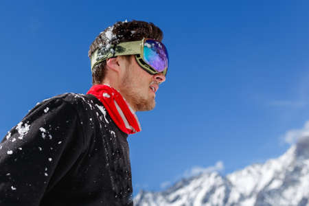 Portrait of a handsome young skier in goggles, ready for a new day on the ski slopes. Italian Alps....