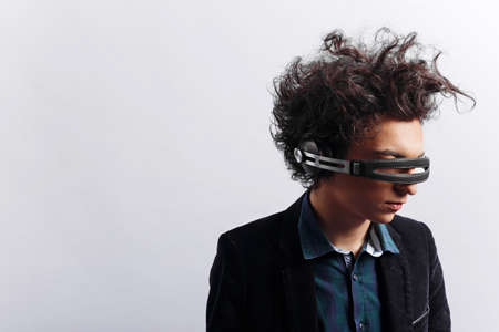 Strange boy with headphones on eyes, picture in profile, dressed in shirt and jacket, on white background.の写真素材