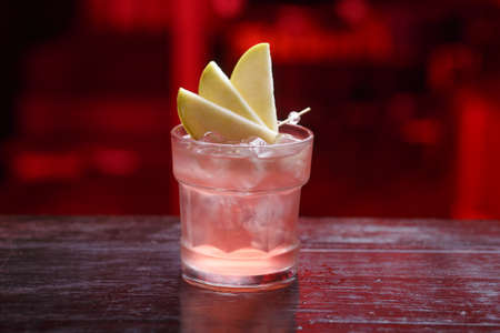 Grapefruit cocktails in short glasses, cold summer citrus refreshing drink or beverage with ice, on a counter bar.の写真素材