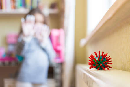 Symbol pandemic Corona virus - Covid 19, blurred background a girl protected with a mask and medical gloves is removed.の写真素材