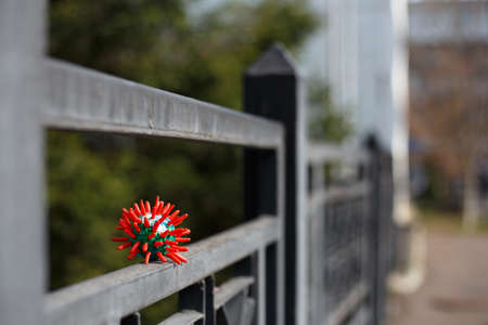 A symbol of the virus Coronavirus Covid -19 of new type placed on a lock of a metal gate.の写真素材