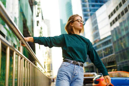 Horizontal portrait of a stylish girl with short hairstyle, in casual clothes, looking down in...