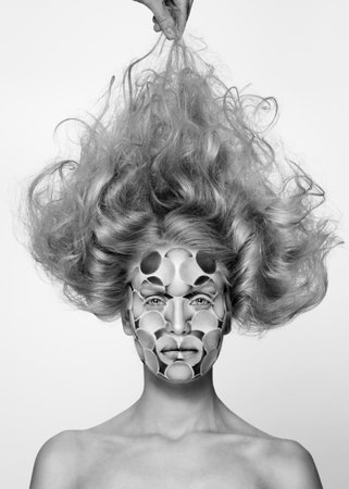 Black and white photo. Woman with colored face painted and tousled hairstyle. Art beauty image.の写真素材