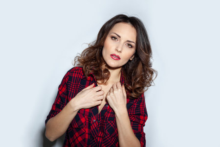 Closeup portrait of a attractive young woman with hairstyle and makeup, posing in studio, over white background.の写真素材