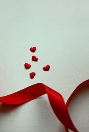 Valentine day love, white paper with red hearts heap spread and ribbon on white background.