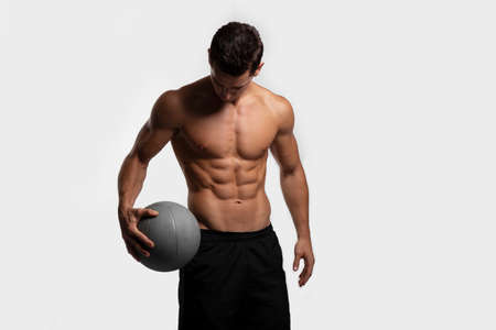 Handsome young fitness sporty strong man bare-chested muscular sportsman basketball player isolated on white background.の写真素材