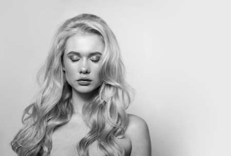 Portrait of young blonde model with bright makeup. Studio photo shoot of pretty woman. Modern fashion and youth concept. Black and white image.の写真素材