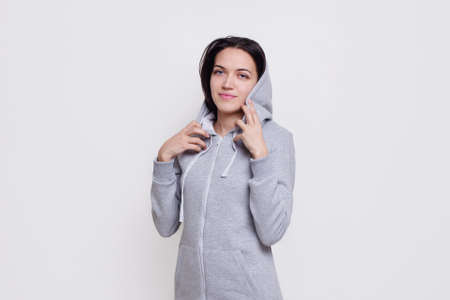 Frontal portrait of a cheerful brunette model dressed in casual clothes, isolated on white background.の写真素材