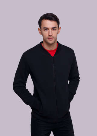 Frontal view of an attractive young brunette man in dark blue jumper and jeans. Studio photo.の写真素材