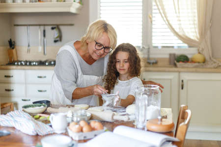 A grandmother and cheerful niece is cooking a cookies.の写真素材