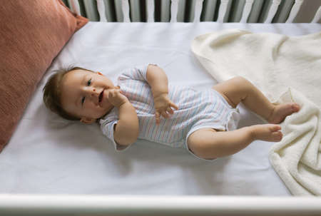 Adorable newborn lies in the cribの写真素材