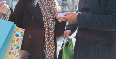 Closeup of young couple with shopping bags and credit cardの写真素材
