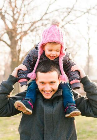 Father holding his daughter on his shoulders. Happy familyの写真素材
