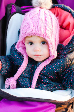 Cute little girl sitting in a stroller