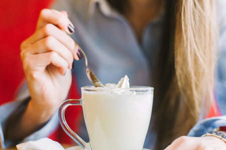 Closeup of woman eating hot chocolate at coffee shopの写真素材