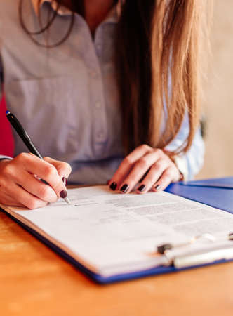 Unrecognisable businesswoman sitting at her office and writingの写真素材