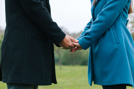 Closeup of young couple holding hands outdoorsの写真素材