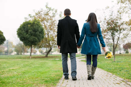 Couple in love holding hands and walking in a park, copy spaceの写真素材