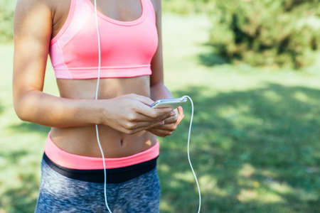 Closeup of runner woman listening music on her phone with copy space