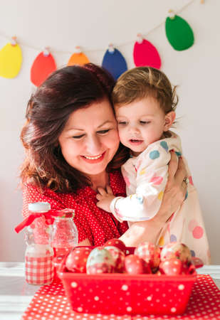 Easter concept. Grandmother holding happy little girl and smilingの写真素材