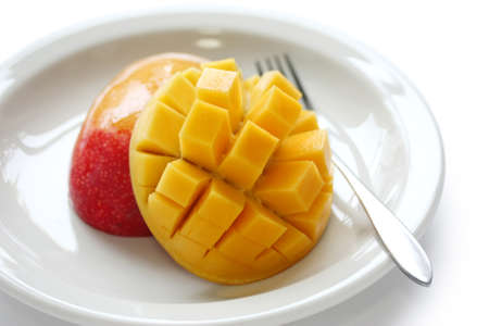 cube cut Mango on a white dishの写真素材