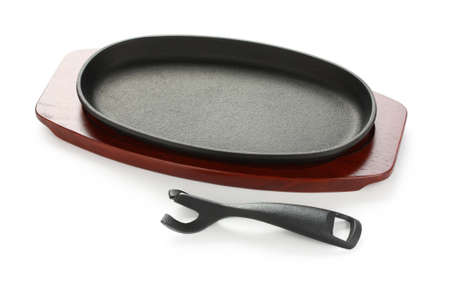 cast iron sizzling steak plate on wooden baseの写真素材