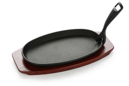 cast iron sizzling steak plate on wooden baseの写真素材