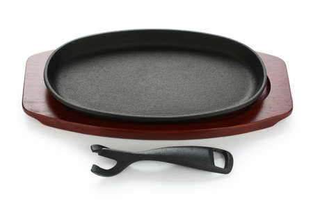 cast iron sizzling steak plate on wooden baseの写真素材
