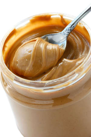 an open jar of peanut butter with spoonの写真素材