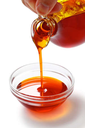 pouring red palm oil into a glass bowlの写真素材