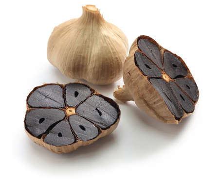 black garlic bulbs and cloves on white backgroundの写真素材