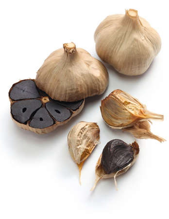 black garlic bulbs and cloves on white backgroundの写真素材